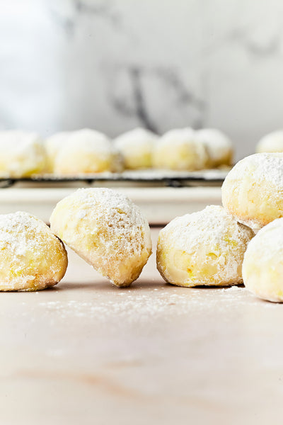 These Mexican wedding cookies are delicate and double-coated in powdered sugar! Orange zest and orange blossom water add bright flavour.